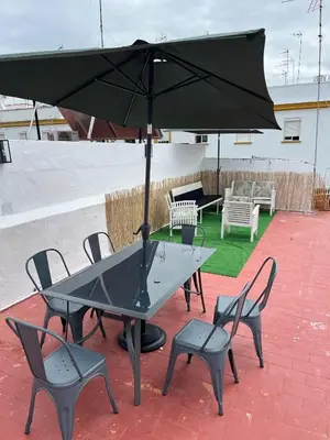 a table and chairs with an umbrella on a patio at Centrally located apartment with terrace in El Puerto de Santa María