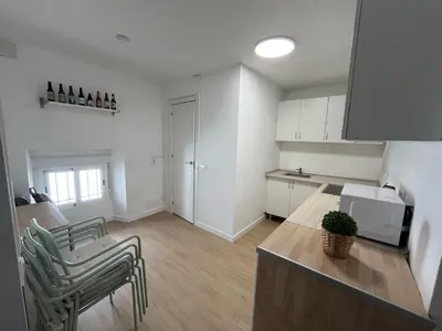a kitchen with a counter and chairs in a room at Centrally located apartment with terrace in El Puerto de Santa María