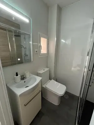 a white bathroom with a sink and a toilet at Centrally located apartment with terrace in El Puerto de Santa María