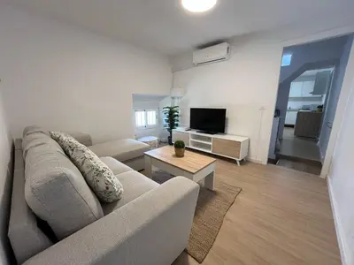 a living room with a couch and a tv at Centrally located apartment with terrace in El Puerto de Santa María