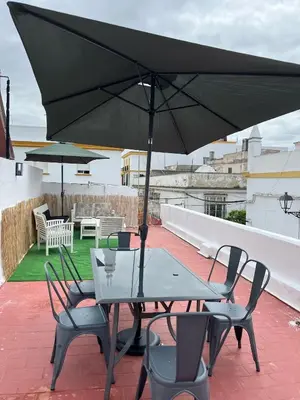 a table and chairs with an umbrella on a roof at Centrally located apartment with terrace in El Puerto de Santa María