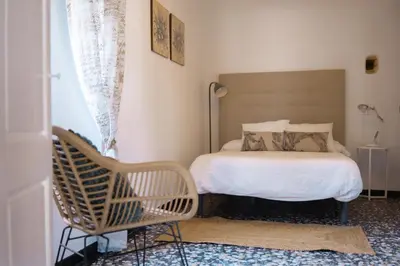 a bedroom with a bed and a chair at Casa Cuesta Belén in Arcos de la Frontera