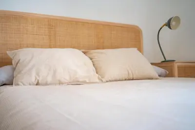 a white bed with a wooden headboard and a pillow at Casa Cuesta Belén in Arcos de la Frontera