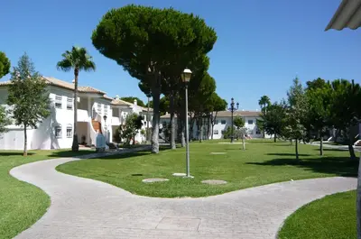 a walkway in a park in front of a house at Residencial Pinar Atlántico in Novo Sancti Petri