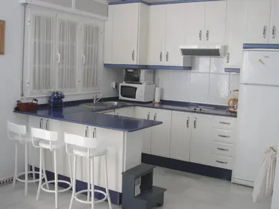 a kitchen with white cabinets and a blue counter top at Residencial Pinar Atlántico in Novo Sancti Petri
