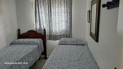 two beds in a small room with a window at Residencial Pinar Atlántico in Novo Sancti Petri