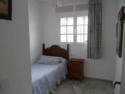 a bedroom with a bed and a window at Residencial Pinar Atlántico in Novo Sancti Petri