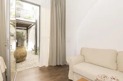 a living room with a white couch and a mirror at Mar Abierto B in Sanlúcar de Barrameda