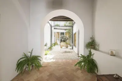 an arched hallway with potted plants in a building at Mar Abierto B in Sanlúcar de Barrameda