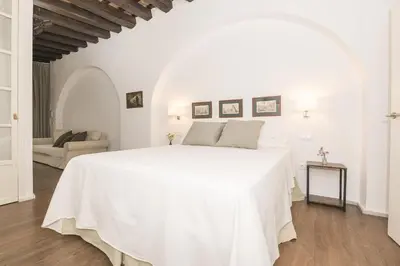 a white bedroom with a large white bed in a room at Mar Abierto B in Sanlúcar de Barrameda