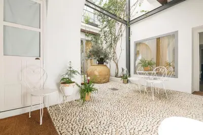 a room with white chairs and potted plants at Mar Abierto A in Sanlúcar de Barrameda