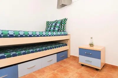 a bed in a room with a pillow and a nightstand at Casa Algodon in Chiclana de la Frontera