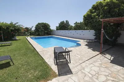 a swimming pool with two chairs and a swing at Casa Algodon in Chiclana de la Frontera
