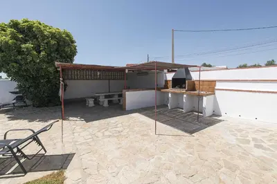 a patio with a table and a grill on a building at Casa Algodon in Chiclana de la Frontera