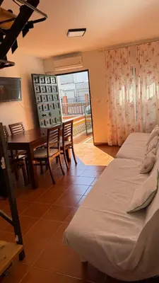 a room with two beds and a table and chairs at Dúplex tras Regla in Chipiona
