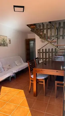 a living room with a table and chairs and a couch at Dúplex tras Regla in Chipiona