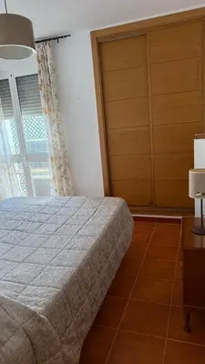 a bedroom with a bed and a dresser and a window at Dúplex tras Regla in Chipiona