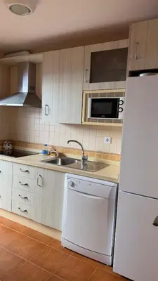 a kitchen with a white refrigerator and a sink at Dúplex tras Regla in Chipiona