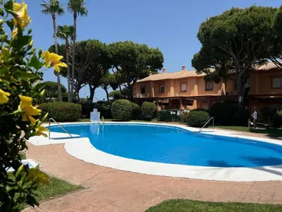 a large blue swimming pool in front of a house at Villa Serena in Chiclana de la Frontera