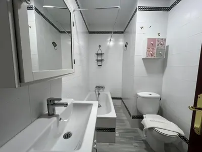 a white bathroom with a sink and a toilet at Villa Serena in Chiclana de la Frontera