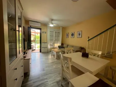 a living room with a table and a couch at Villa Serena in Chiclana de la Frontera