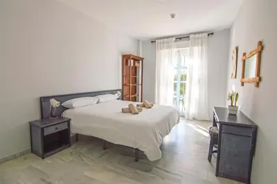 a bedroom with a bed with two teddy bears on it at Brisa del Mar II, Apartamentos Living Sur in Sanlúcar de Barrameda