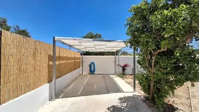 a white garage with a fence and a blue object at PASSIVE HOUSE in Novo Sancti Petri