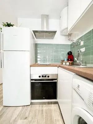 a kitchen with white appliances and green tiles at Apartamento La Sal Centro in San Fernando
