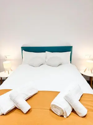 a white bed with two pairs of socks on it at Apartamento La Sal Centro in San Fernando