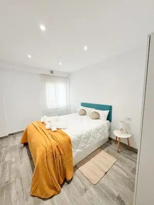 a bedroom with a bed with a yellow blanket on it at Apartamento La Sal Centro in San Fernando