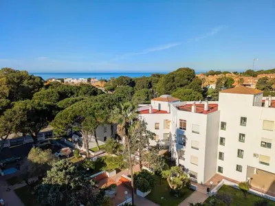an overhead view of a building with trees and the ocean at Anc14 Apartamento con 2 habitaciones, patio y piscina al lado de la playa in El Puerto de Santa María