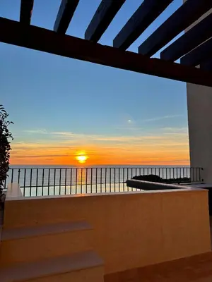 a view of the sunset from the balcony of a house at Hotel Punta Bermeja Premium in El Puerto de Santa María
