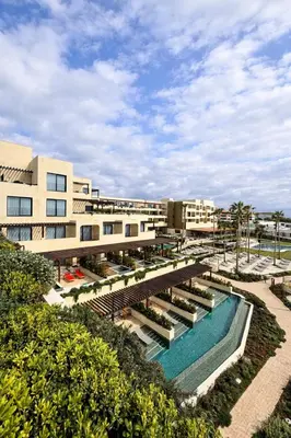 a resort with a swimming pool and a building at Hotel Punta Bermeja Premium in El Puerto de Santa María