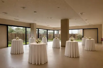 a room with white tables with flowers on them at Hotel Punta Bermeja Premium in El Puerto de Santa María