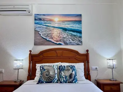 a bedroom with a bed with a picture of the ocean at GATU Villa Flavia 