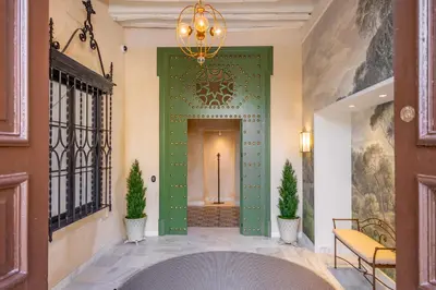 a green door in a hallway with two plants at Aladro Apartamentos by Valcambre in Jerez de la Frontera