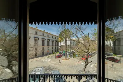 a white building with balconies and a door at Aladro Apartamentos by Valcambre in Jerez de la Frontera