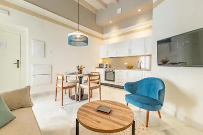 a living room with a couch and a table and chairs at Aladro Apartamentos by Valcambre in Jerez de la Frontera