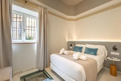 a white bathroom with a sink and a mirror at Aladro Apartamentos by Valcambre in Jerez de la Frontera
