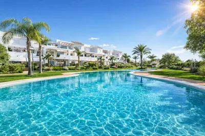 a swimming pool at a resort with palm trees at Chic & Bright Costa Ballena Getaway in Chipiona