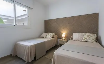 a bedroom with two beds and a window at Chic & Bright Costa Ballena Getaway in Chipiona