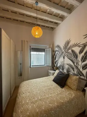 a bedroom with a bed with a plant mural on the wall at Cádiz Paz in Cádiz