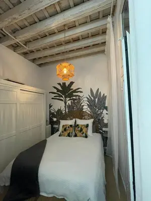 a bedroom with a white bed and a chandelier at Cádiz Paz in Cádiz