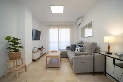 a living room with a couch and a table at SIBS Sanlúcar Camelias-Ideal Familias Cerca Playa in Sanlúcar de Barrameda