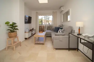 a living room with a couch and a table at SIBS Sanlúcar Camelias-Ideal Familias Cerca Playa in Sanlúcar de Barrameda