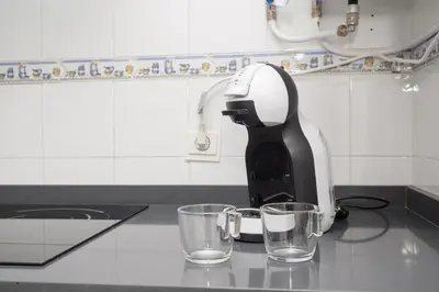 a coffee maker and two glasses on a kitchen counter at SIBS Sanlúcar Camelias-Ideal Familias Cerca Playa in Sanlúcar de Barrameda