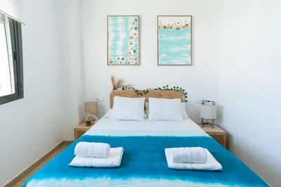 a bedroom with a blue bed with two white pillows at Acogedor apartamento céntrico in El Puerto de Santa María
