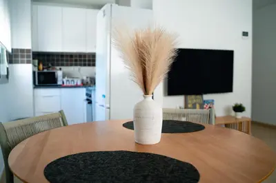 a white vase sitting on a wooden table at Acogedor apartamento céntrico in El Puerto de Santa María