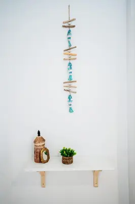 a white shelf with books and a plant on it at Acogedor apartamento céntrico in El Puerto de Santa María