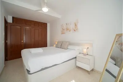 a bedroom with a white bed and a mirror at SIBS Sanlúcar Océano-Ideal Familias-Parking y Wifi Gratis in Sanlúcar de Barrameda